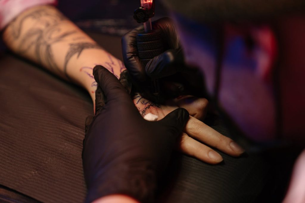 pexels photo 4125589 Tattoo artist skillfully inking a design on client's arm with precision.